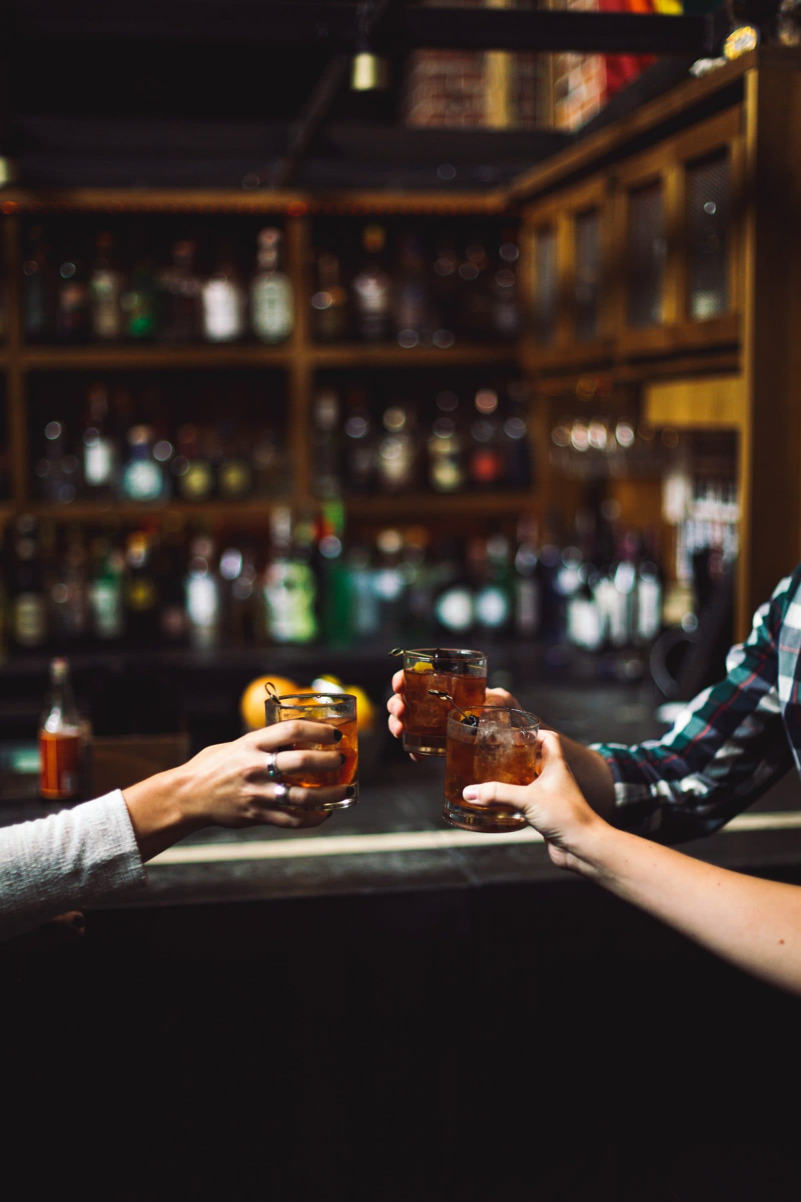 Friends toasting whisky at a bar